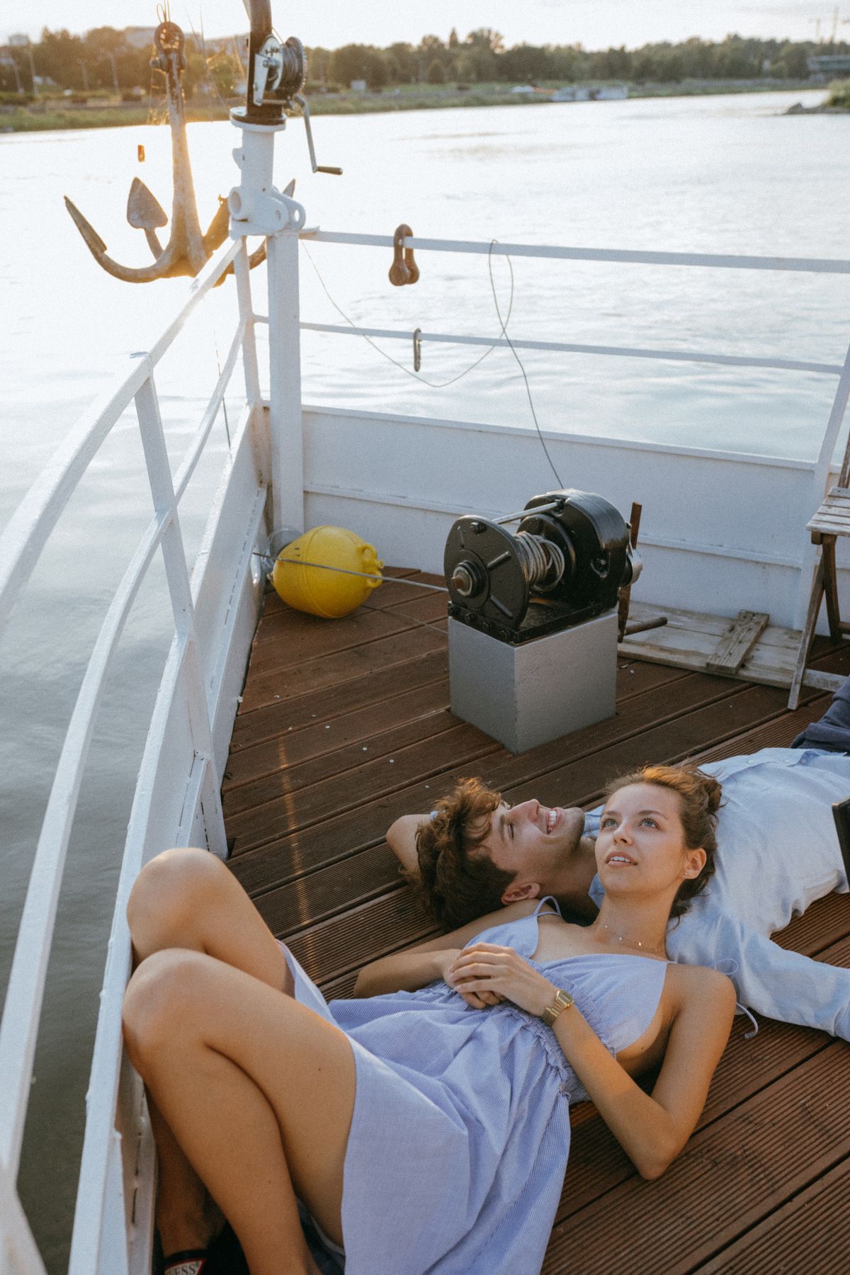 Couple relaxing on the deck of a boat at sunset