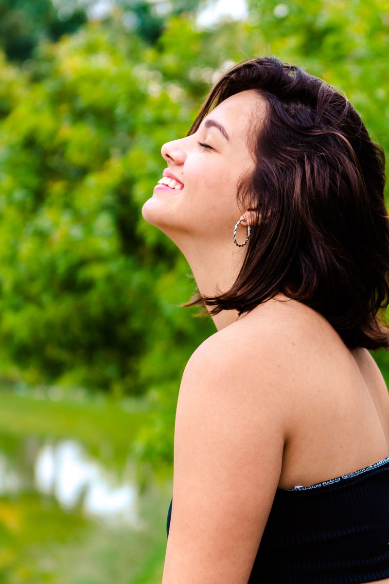 Joyful woman with short dark hair smiling outdoors in a park