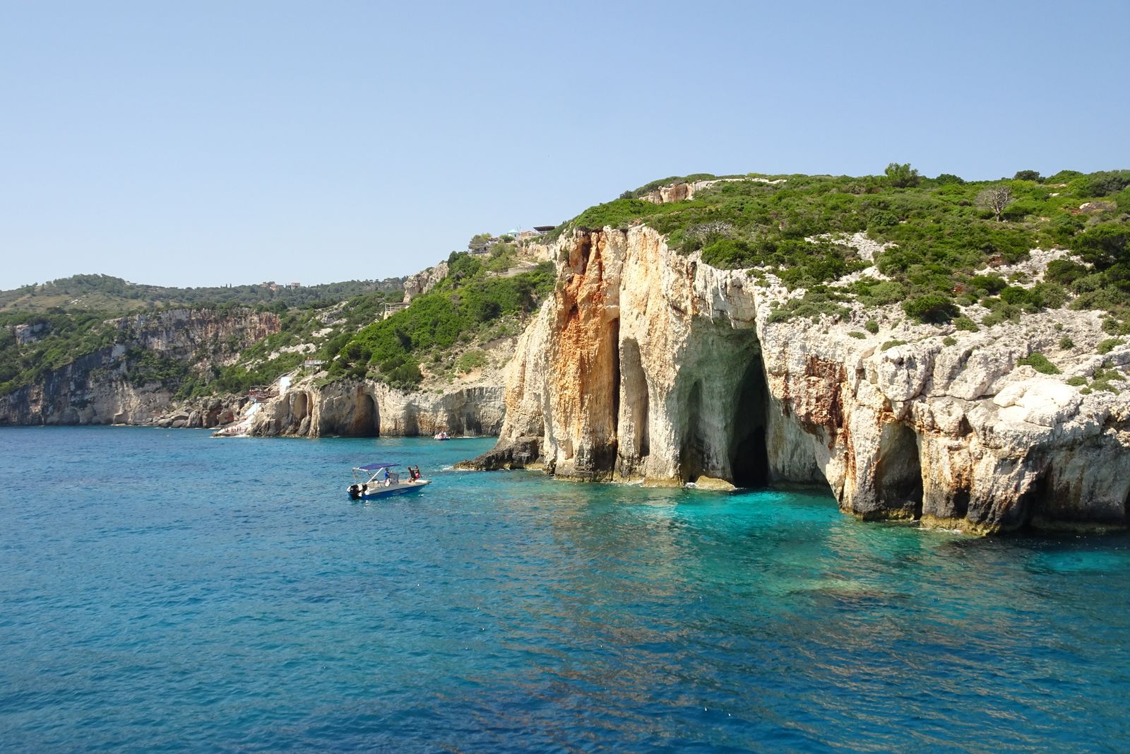 Limestone cliffs meeting turquoise sea, viewed from the water